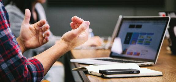 Person in Meeting mit Laptop